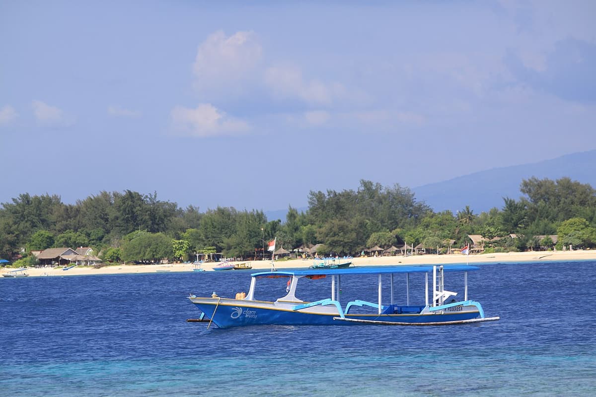 Perahu cadik tradisional di air toska yang dangkal di Kepulauan Gili