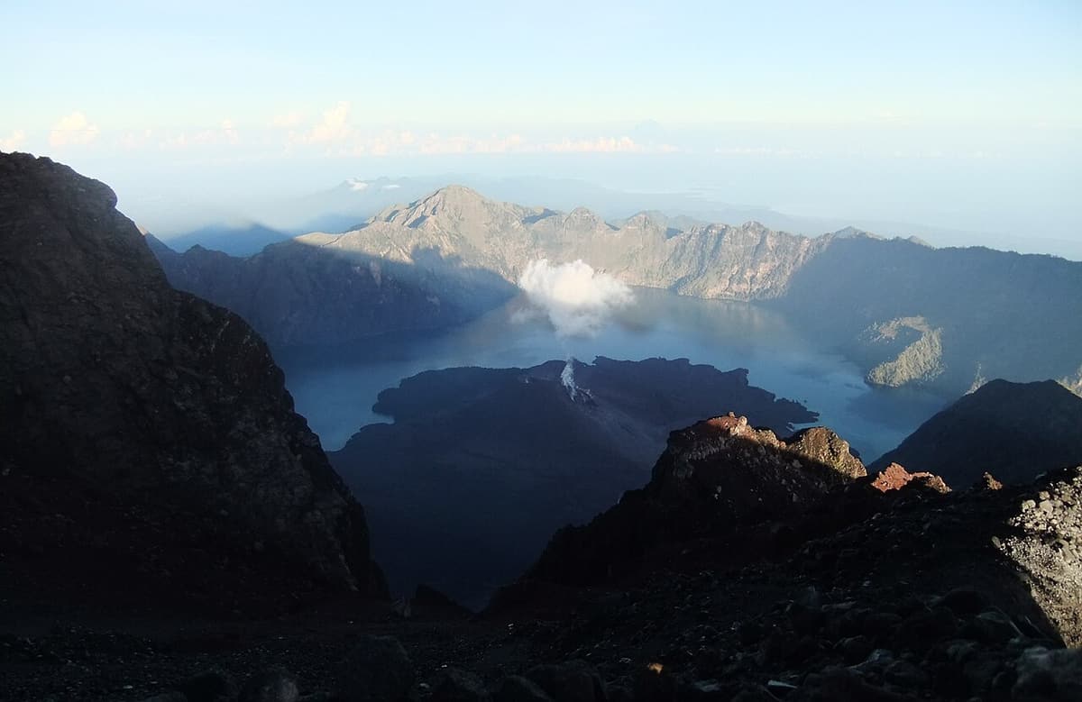 Danau kawah Segara Anak dan kerucut Barujari dilihat dari puncak Rinjani